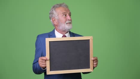 hombre de negocios barbudo y guapo contra un fondo verde.