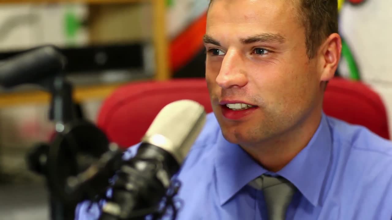 Smiling student reading the news on radio in the studio