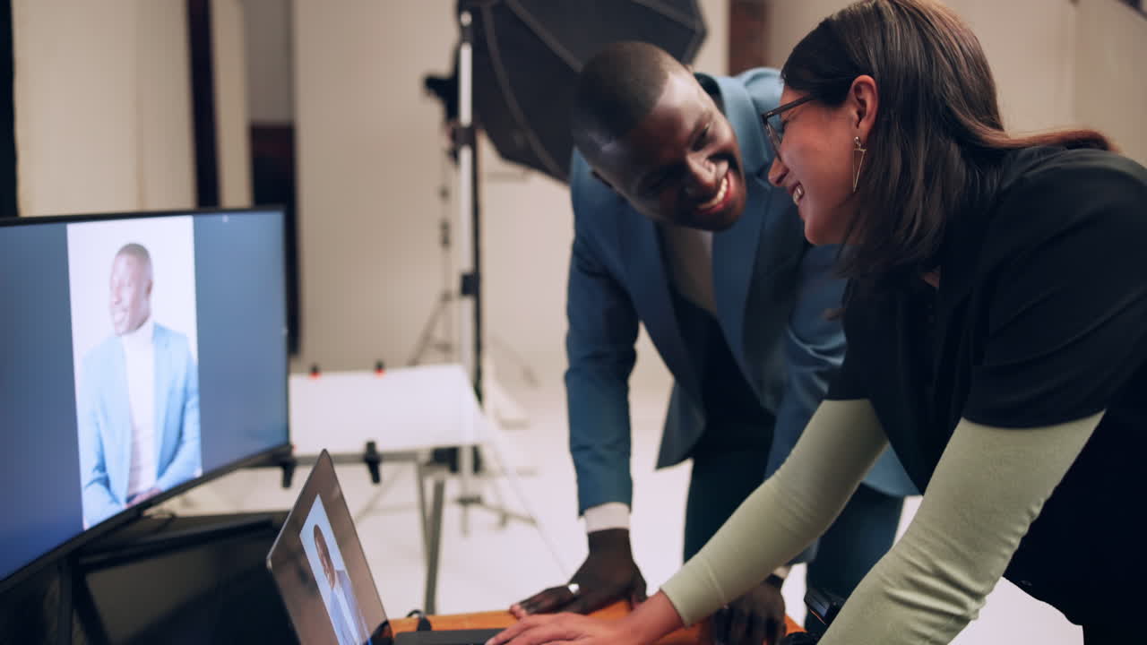 Two people looking at a computer screen in a studio