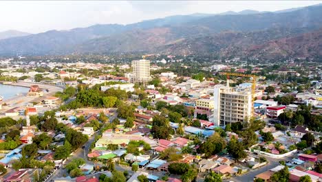 static aerial drone landscape view of capital city of dili, timor-lest in southeast asia with new high rise building developments and residential houses