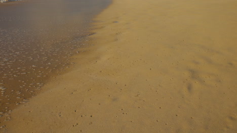 Meerwasser-Kehrt-An-Einem-Sandstrand-Ins-Meer-Zurück