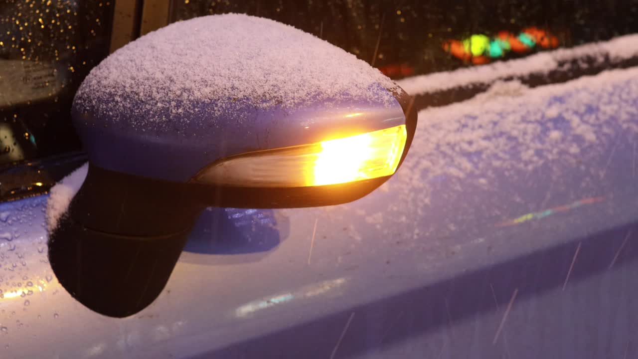 겨울 길에서 차. 후방 거울의 클로즈업. 박이는 알람.