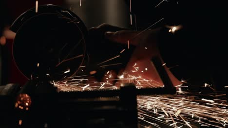 close up of circular saw starting and creating sparks in dark workshop