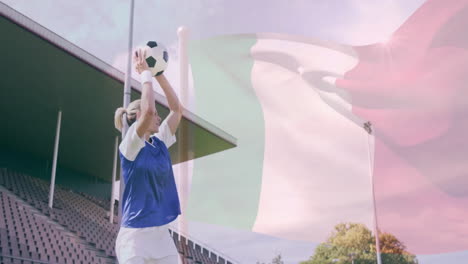holding soccer ball with italian flag, player standing at outdoor stadium