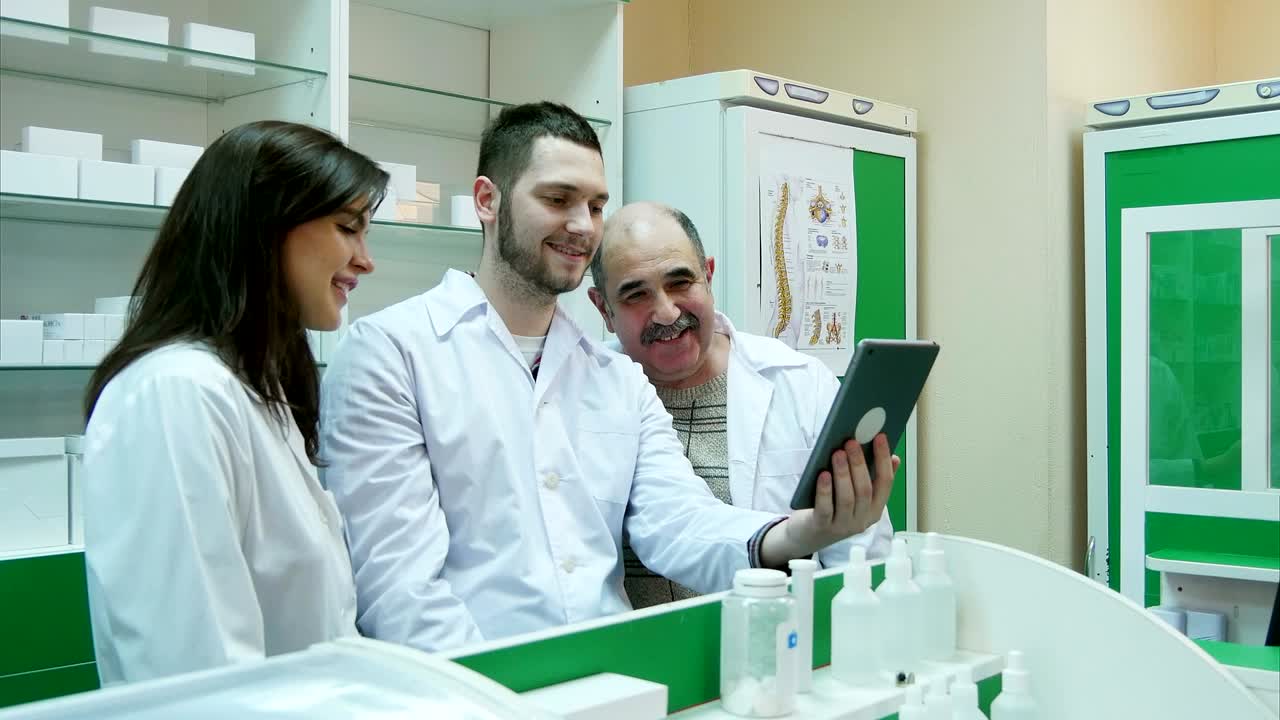 약국에서 디지털 태블릿을 사용하여 비디오 채팅을 하는 약사 팀