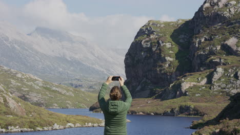 woman using smartphone taking photos young female tourist enjoying beautiful scenic river landscape sharing vacation travel experience on mobile phone social media