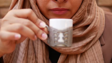 mujer en hijab bebiendo café
