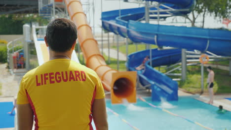 a man in a yellow t-shirt with an inscription on the back of the rescuer watching children roll on t