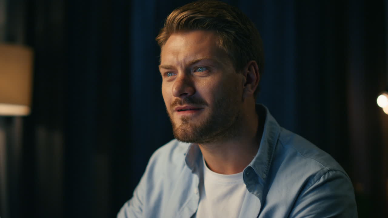 un hombre positivo bailando en una silla en casa de cerca. un tipo escuchando música rítmica solo.
