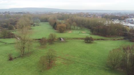 Aerial-view-overcast-frosty-green-golf-course-country-club-fairway-wide-orbit-right