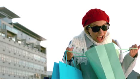 una chica bonita se sorprende mirando en una bolsa de compras