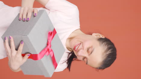 Vertikales-Video-Einer-Glücklichen-Und-Fröhlichen-Frau,-Die-Das-Geschenkpaket-öffnet.