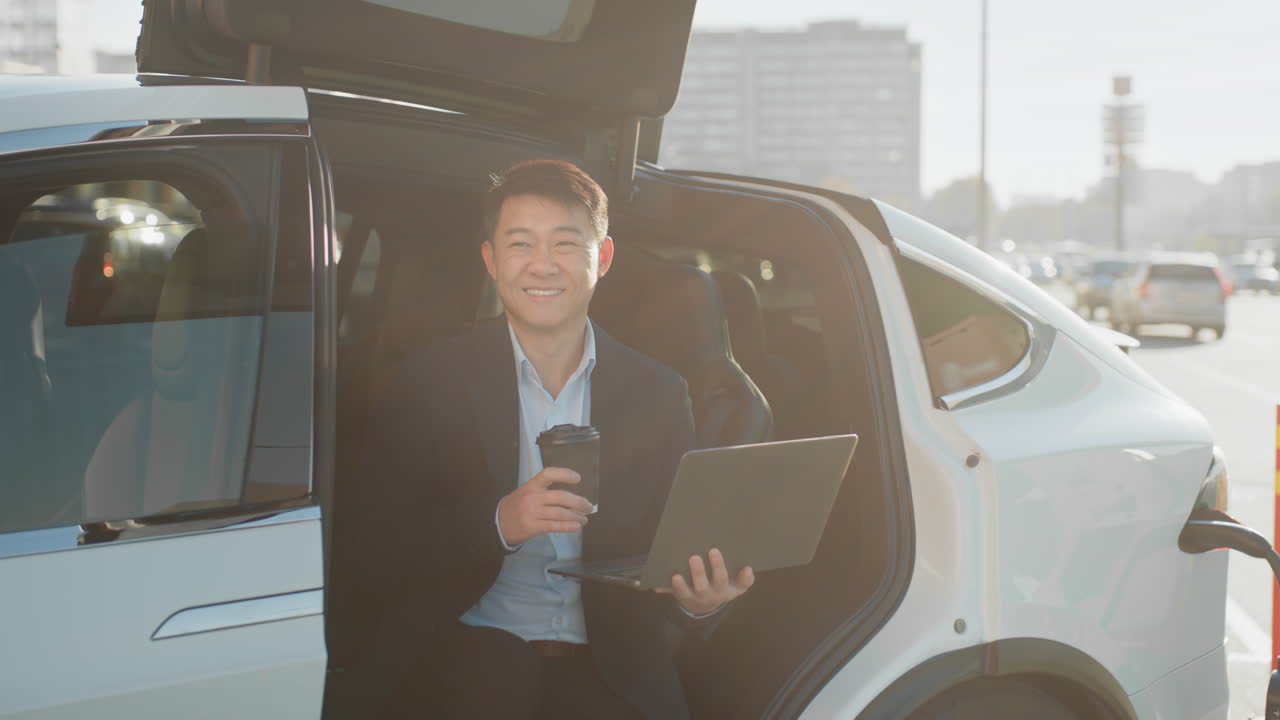 電気自動車の中で仕事をするビジネスマン