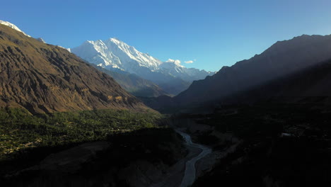 cinematic drone shot of the valley, passu cones in hunza pakistan, snow covered mountain peaks with steep cliffs, high wide aerial shot