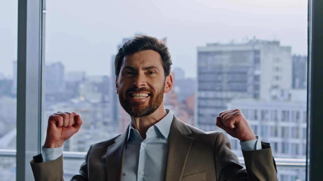 Emotional businessman rejoicing success looking camera cityscape room portrait
