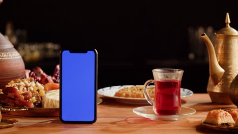 mobile phone on a table with traditional middle eastern food and drink