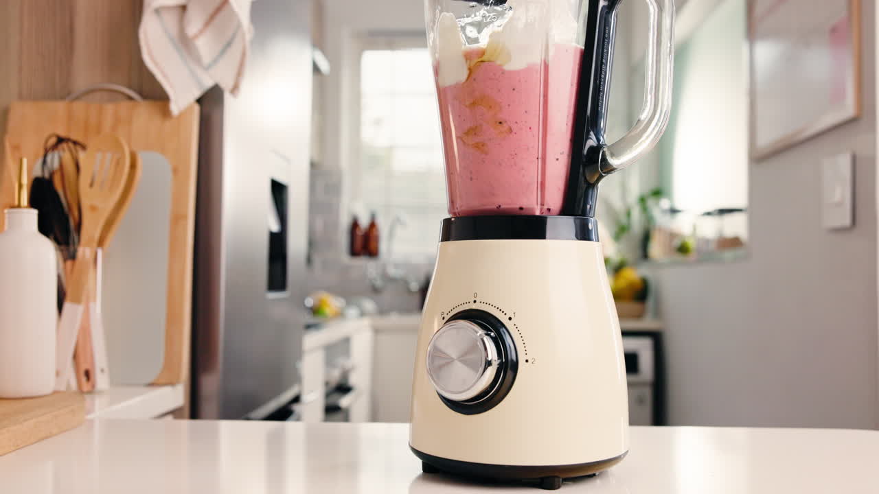 Blender med smoothieingredienser på et køkkenbord