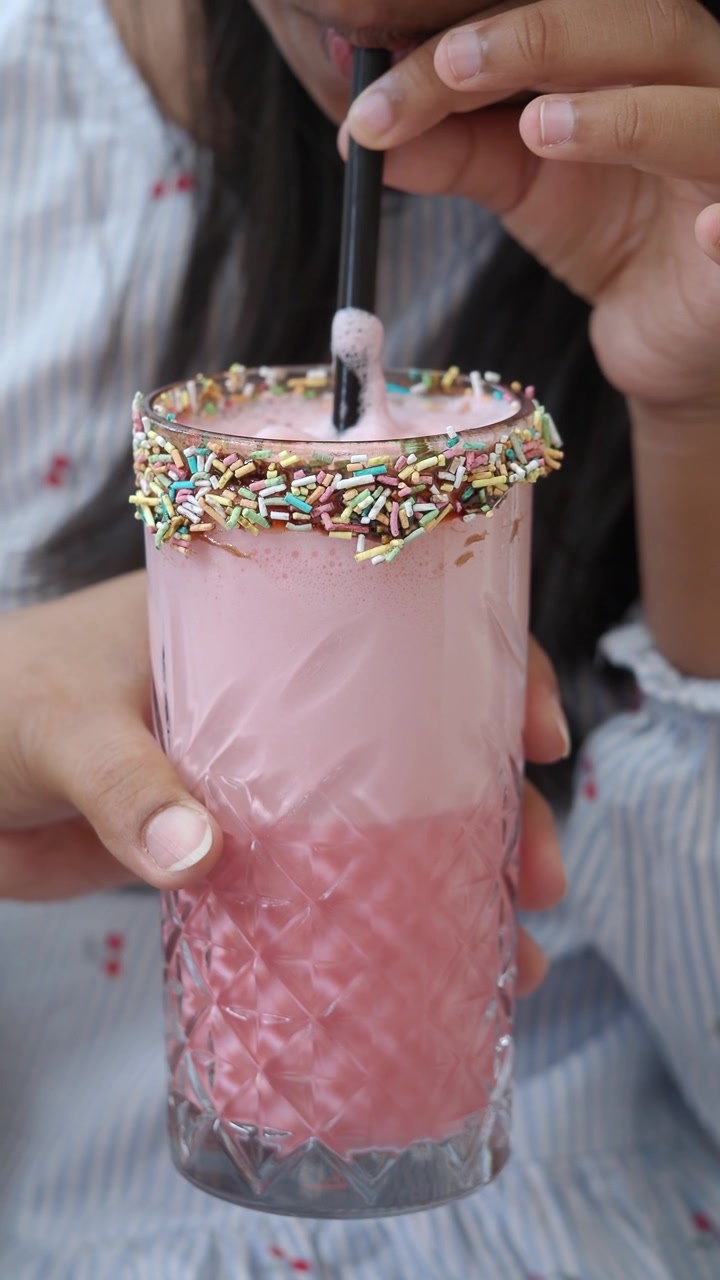 Giovane Ragazza che Beve un Milkshake Rosa con Codette