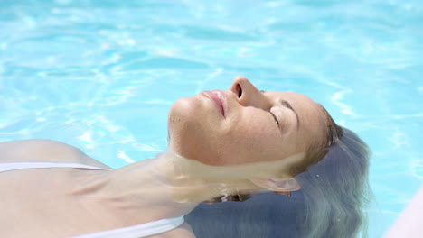 Mujer-Atractiva-Flotando-En-La-Piscina