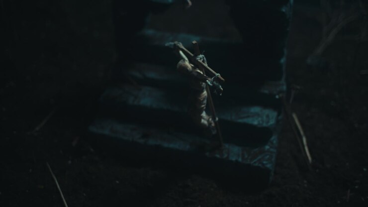 Miniature mummified dolls hanging on the gallows at night