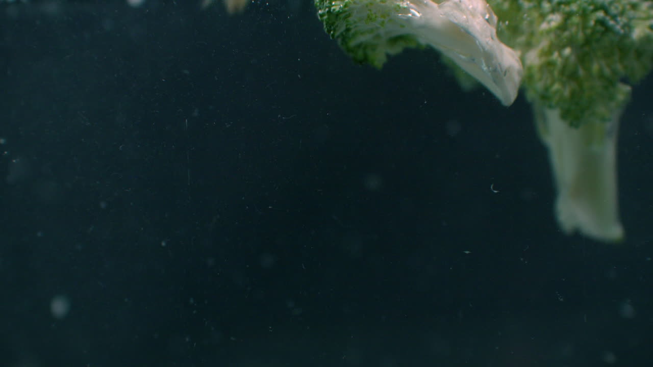 Green fresh broccoli washed in clear water before cooking slow motion