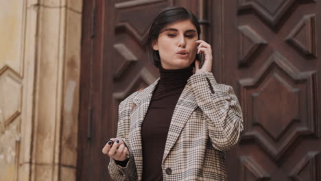 caucasian businesswoman using smartphone outdoor.