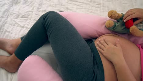 happy pregnant woman sleeping on bed in bedroom.