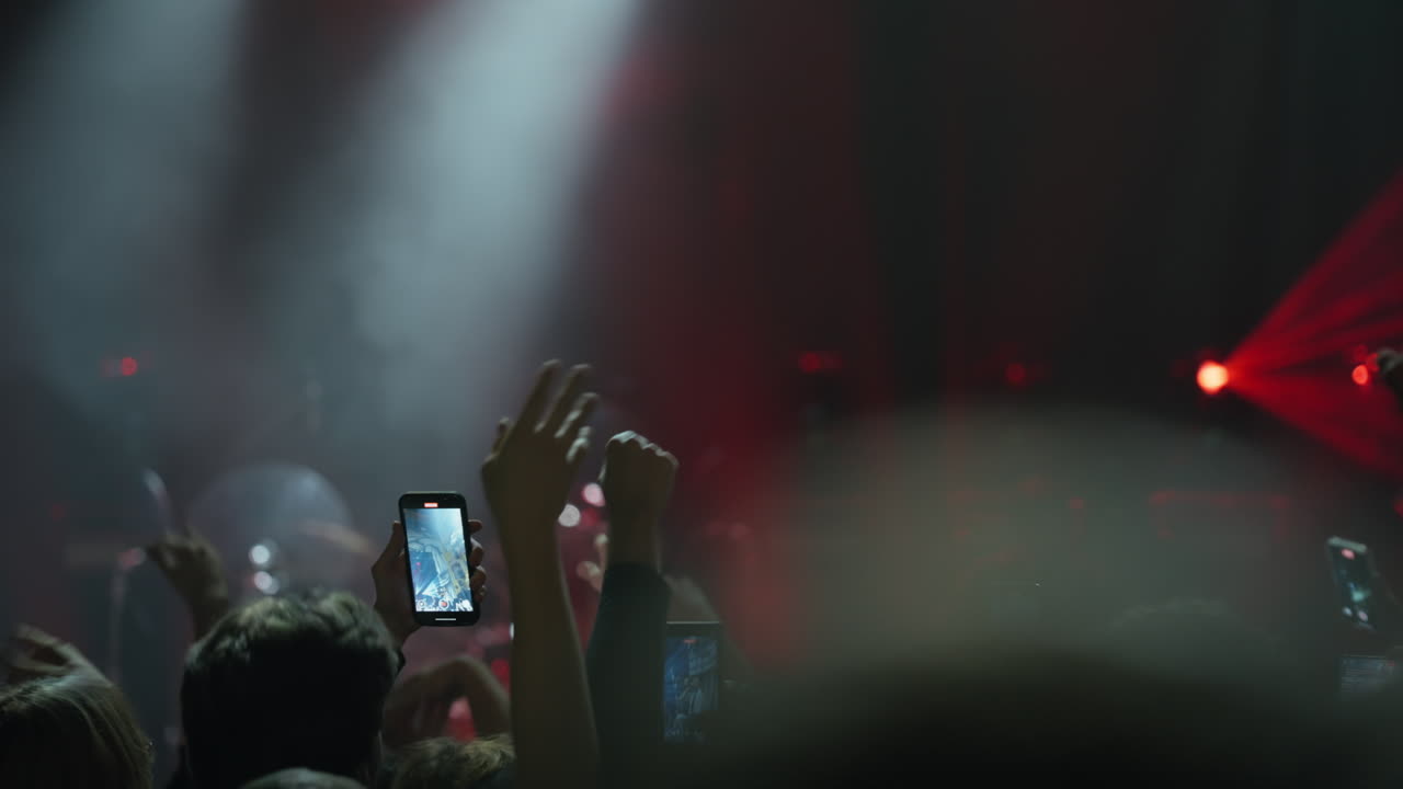 Persone del pubblico che registrano un concerto dal vivo con smartphone
