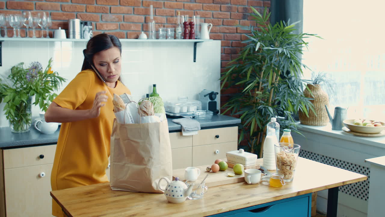 chica sonriente hablando por teléfono en la cocina