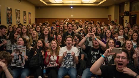 a thrilling crowd celebration: enthusiastic fans enjoying a memorable event with joyful expressions, posters, and excitement in an engaging atmosphere