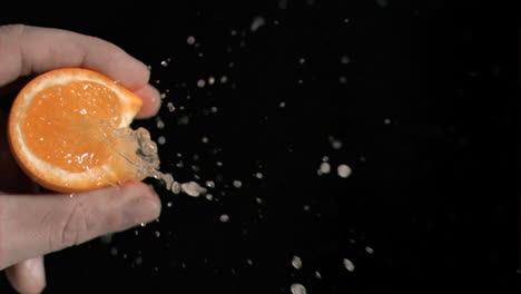 orange being squeezed in super slow motion