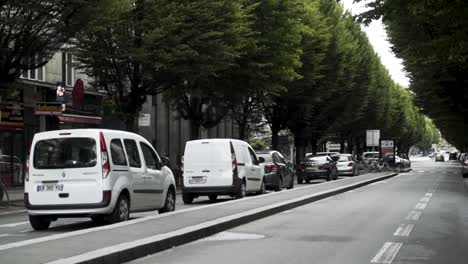 european city street scene with parked cars and trees