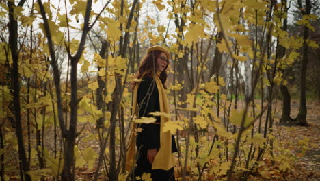 elegant lady strolling through the woods, enjoying the tranquility of nature as autumn leaves sway gently with the wind, wearing a stylish yellow beret and scarf