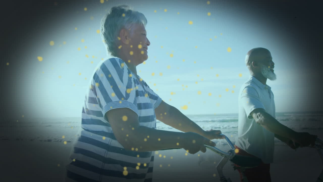 Elderly couple riding bicycles on beach with glowing particles animation