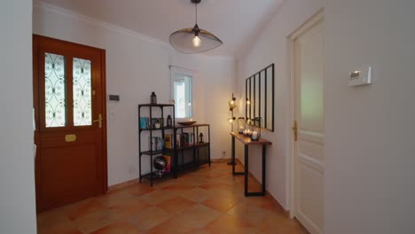 slow dolly shot of a home front doorway with bookshelves and candles burning