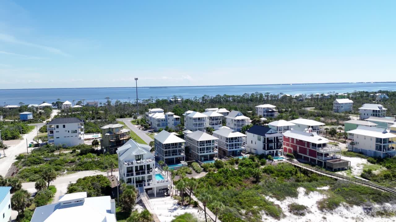 Dynamic drone fly over modern homes at long ocean shoreline of Cape San Blas, Gulf County, Florida, USA
