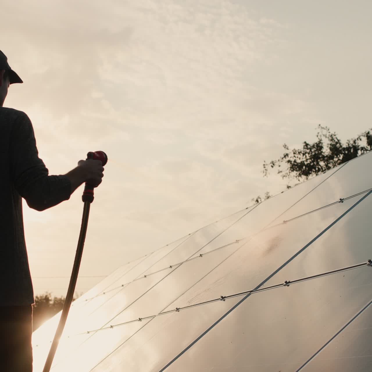 silueta de un hombre lavando un panel de planta de energía solar 1