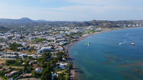 aerial tracking in front of the beach and town, sunny day in faliraki, rhodes