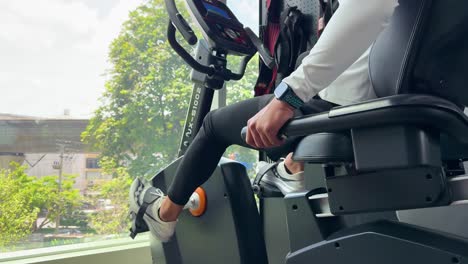 person exercises on a magnetic recumbent bike indoors. bright natural lighting, focused on fitness and health