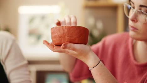 woman creating a clay bowl