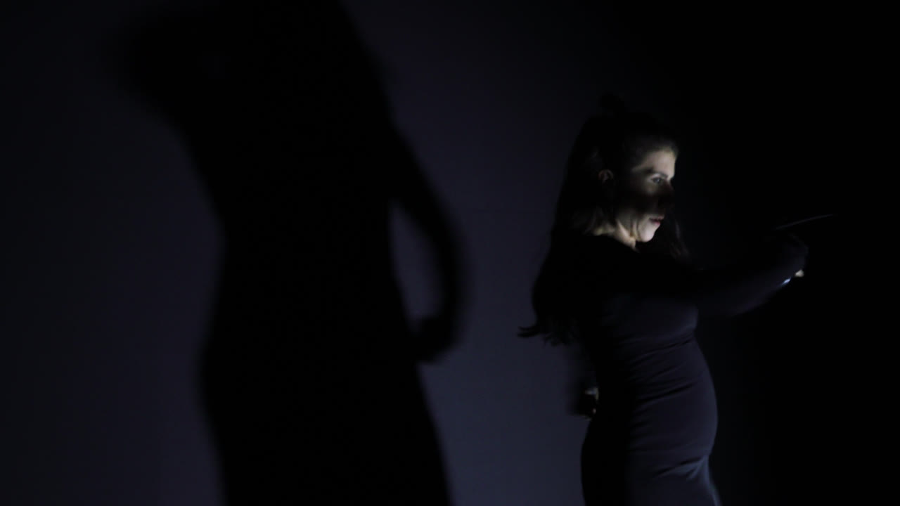 Woman in black dress dancing flamenco with castanets on stage. Gimbal, close up