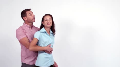 pareja casual abrazándose y señalando