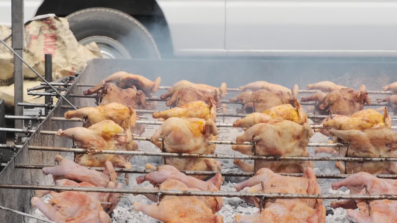 Rows of whole chickens roast over open flames on custom barbecue trailers, filling the Hawaiian North Shore air with the scent of charcoal.