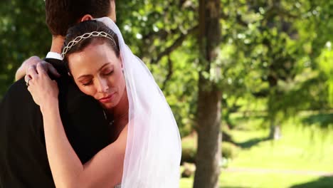 sposa sorridente che abbraccia il suo nuovo marito