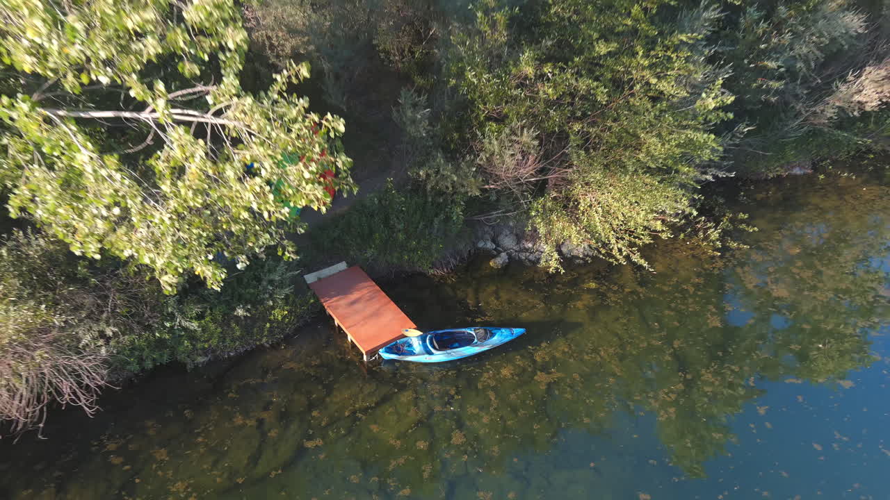 un kayak en un pequeño muelle de madera en el río ruso en el centro de california - retroceda la vista aérea ascendente