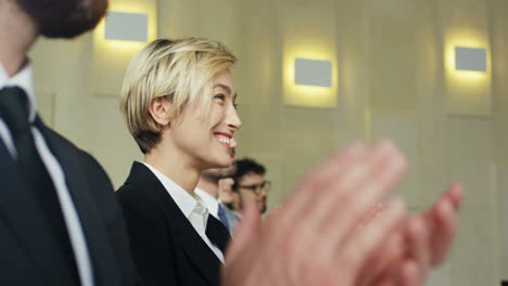 close-up view of caucasian businesswoman hands clapping among the audience in a conference room