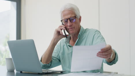 senior man on phone checking documents