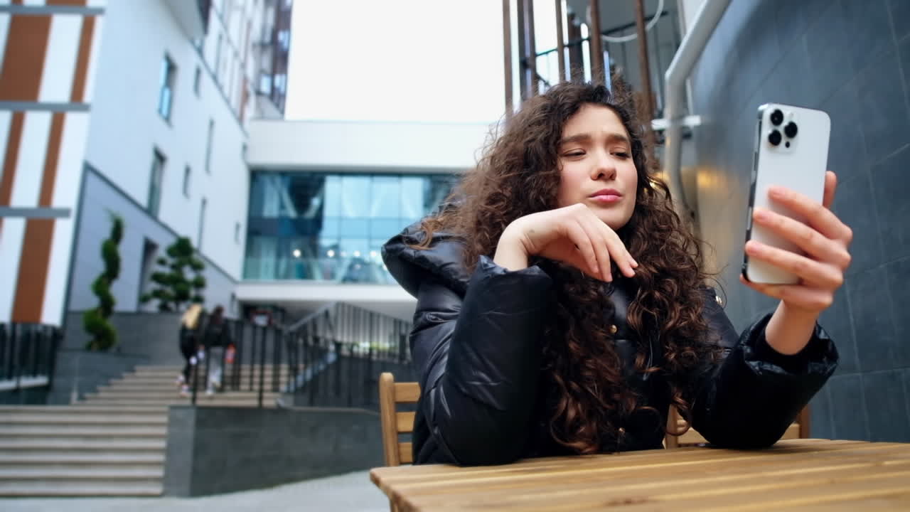 Una giovane blogger influencer si riprende con lo smartphone
