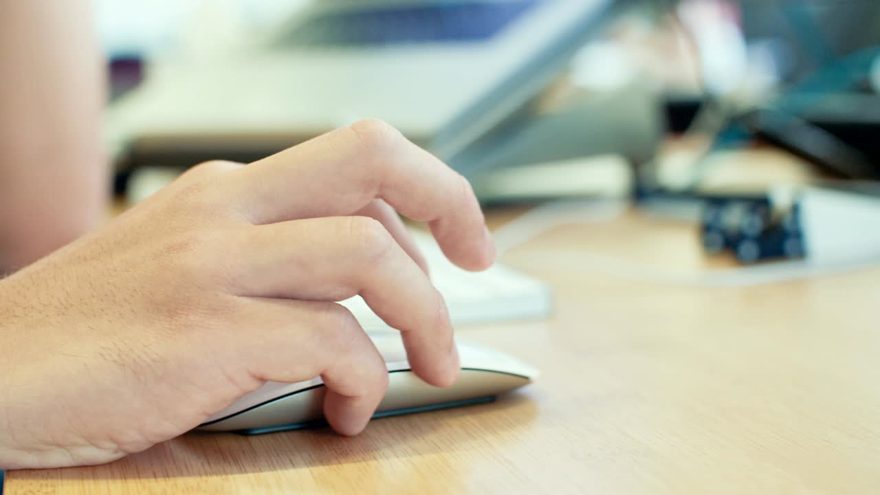 hombre trabajando con un ratón inalámbrico en un escritorio