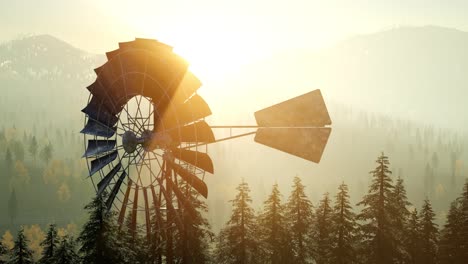 typical old windmill turbine in forest at sunset